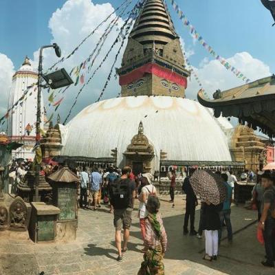 People walking in front of large Asian structure