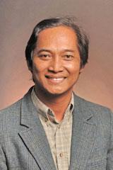 Peter Suwarno wearing gray blazer smiling into camera